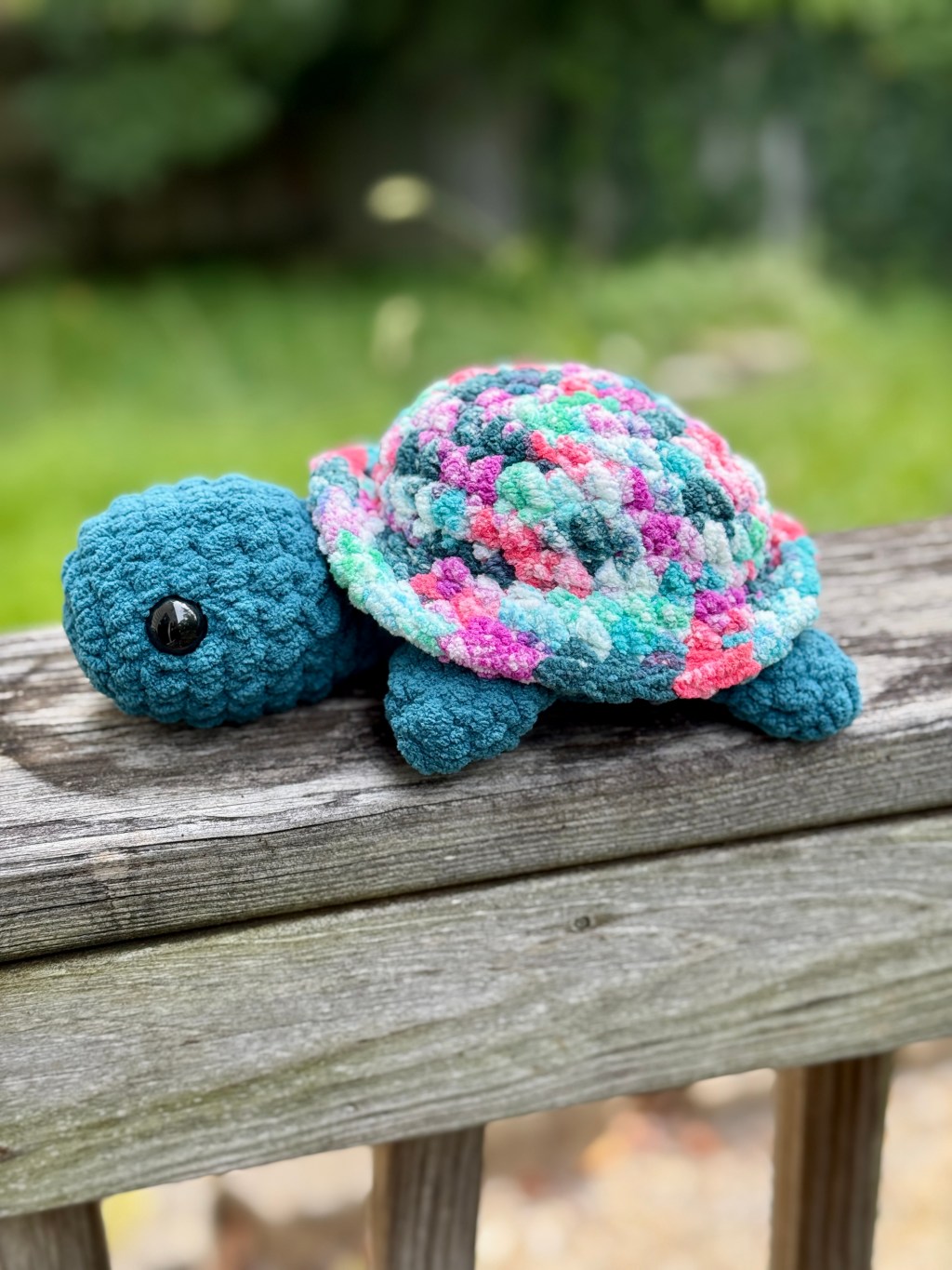 Jerry the Tie-Dye Turtle crochet amigurumi plushie toy handmade craft finished object made with green, blue, pink, and purple tie-dye yarn for the shell and teal blue yarn for the head and body