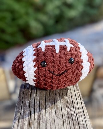 Crochet amigurumi football plushie toy handmade craft finished object with a cute smiling face