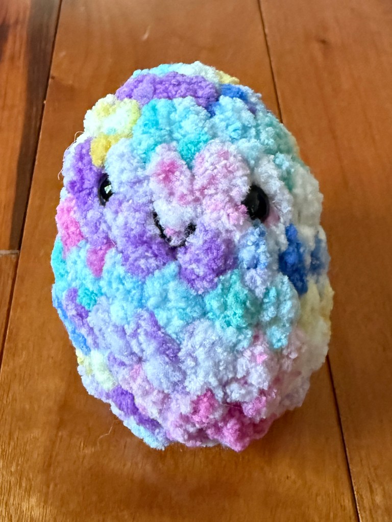 Single rainbow tie-dye kawaii amigurumi crocheted Easter egg made with Premier Basix Chenille Tie Dye chunky yarn