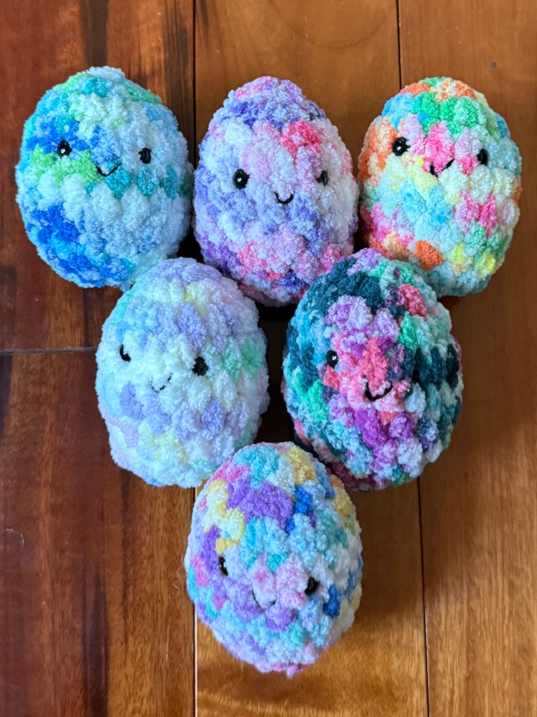 6 colorful tie-dye kawaii amigurumi crocheted Easter eggs made with Premier Basix Chenille Tie Dye chunky yarn