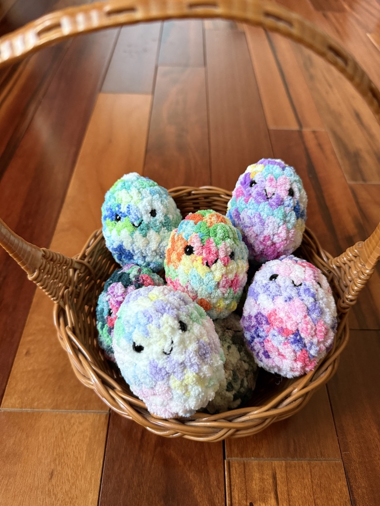 Basket of colorful tie-dye kawaii amigurumi crocheted Easter eggs made with Premier Basix Chenille Tie Dye chunky yarn