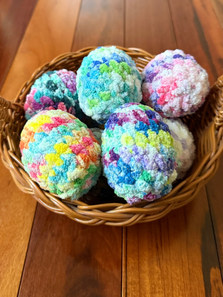Basket of colorful tie-dye amigurumi crocheted Easter eggs made with Premier Basix Chenille Tie Dye chunky yarn