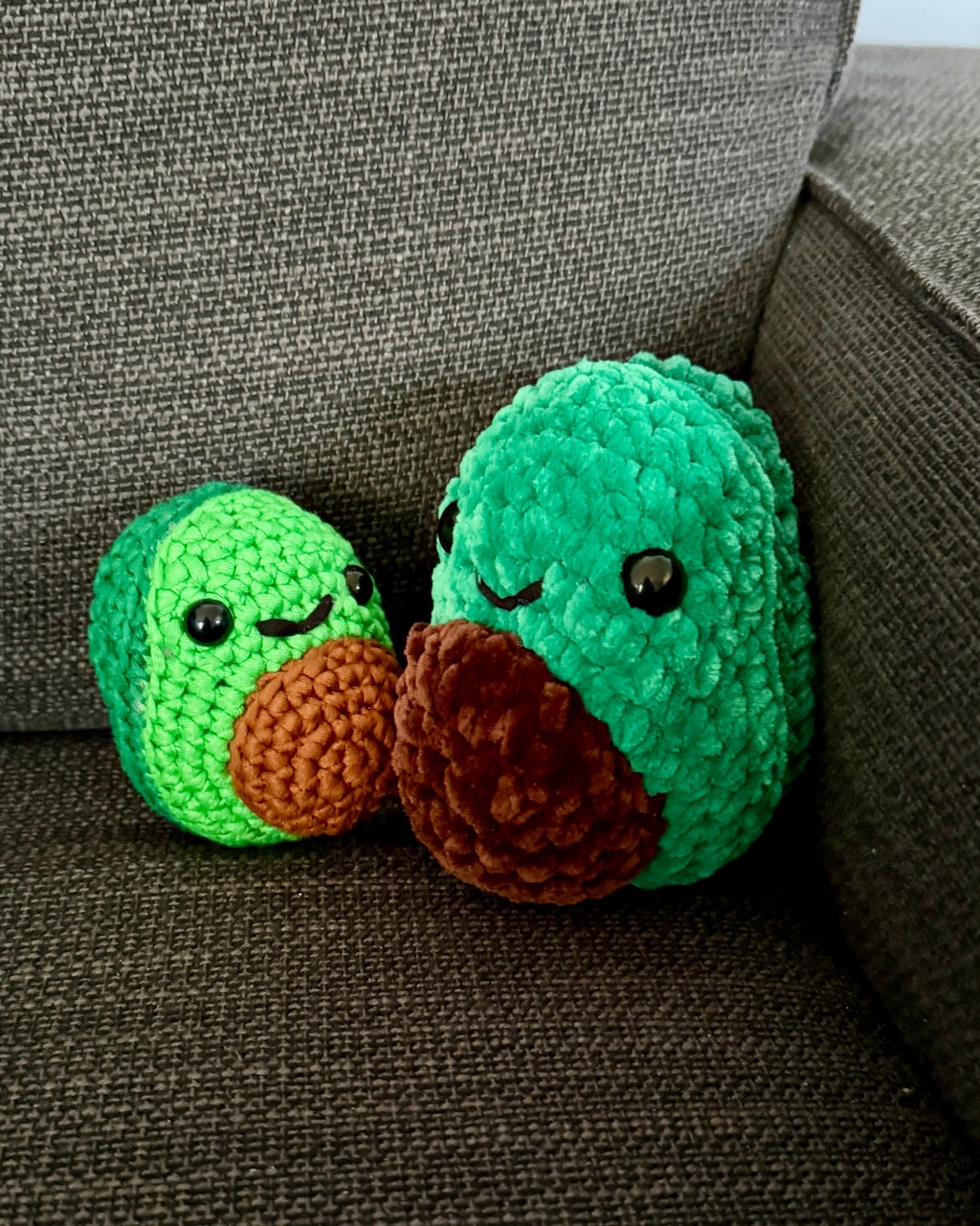 2 crochet amigurumi avocado plushies: smaller one made from Woobles learn to crochet kit on the left and bigger one made with Premier Parfait Chunky chenille yarn on the right
