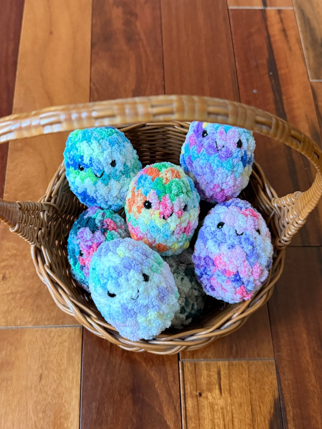 Basket of colorful tie-dye kawaii amigurumi crocheted Easter eggs made with Premier Basix Chenille Tie Dye chunky yarn