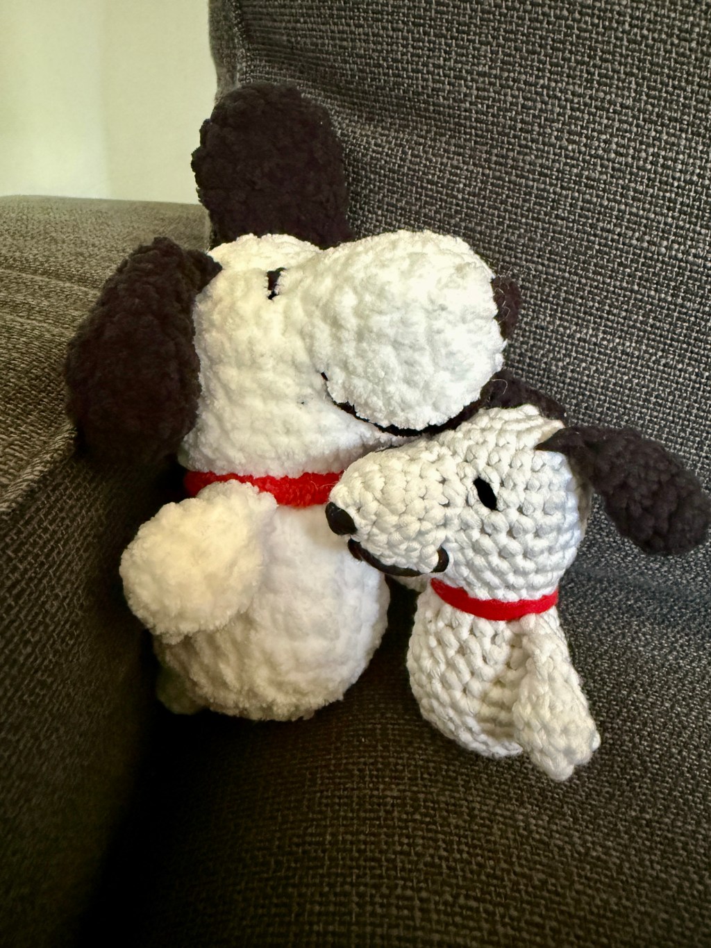 2 crocheted amigurumi handmade plushy Snoopys: 1 made with chunky chenille yarn and 1 made from the Woobles learn to crochet kit's Easy Peasy yarn
