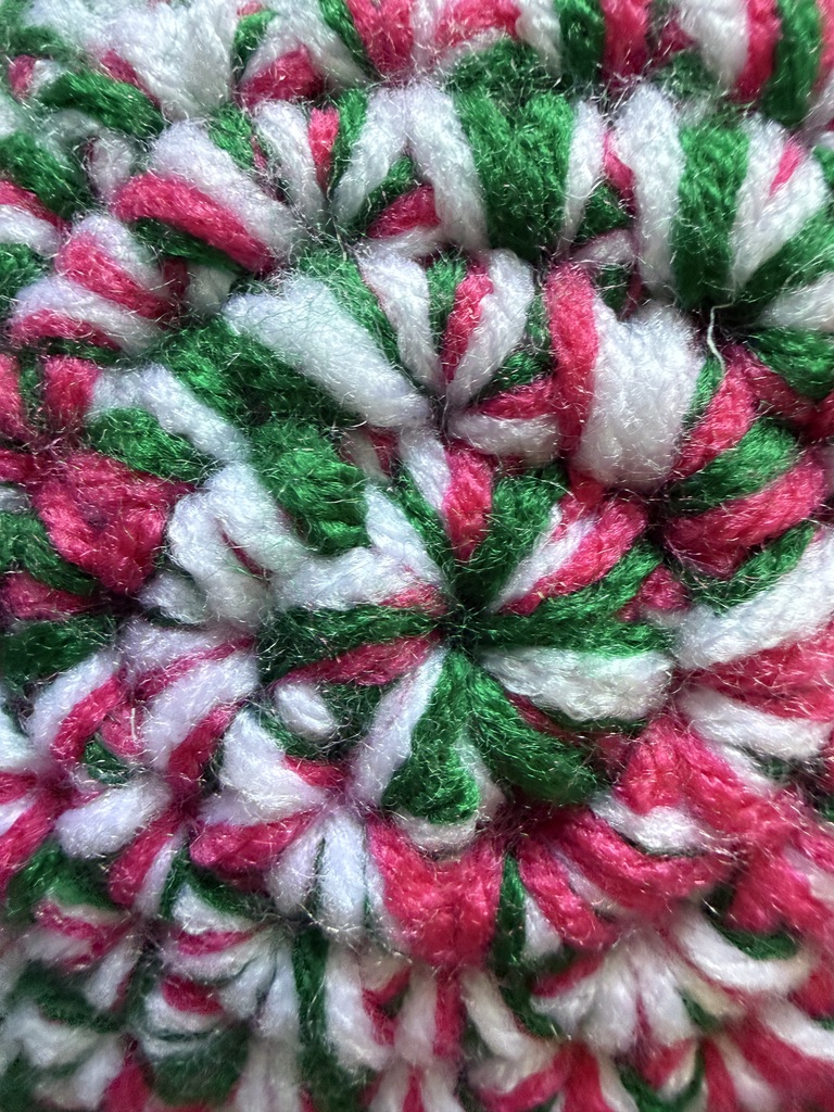 Marbled Star crochet plush pillow close-up with 3 strands of yarn marled together: Emerald Watermelon color palette (pink, green, and white)